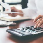 Gros plan d'une main utilisant une calculatrice