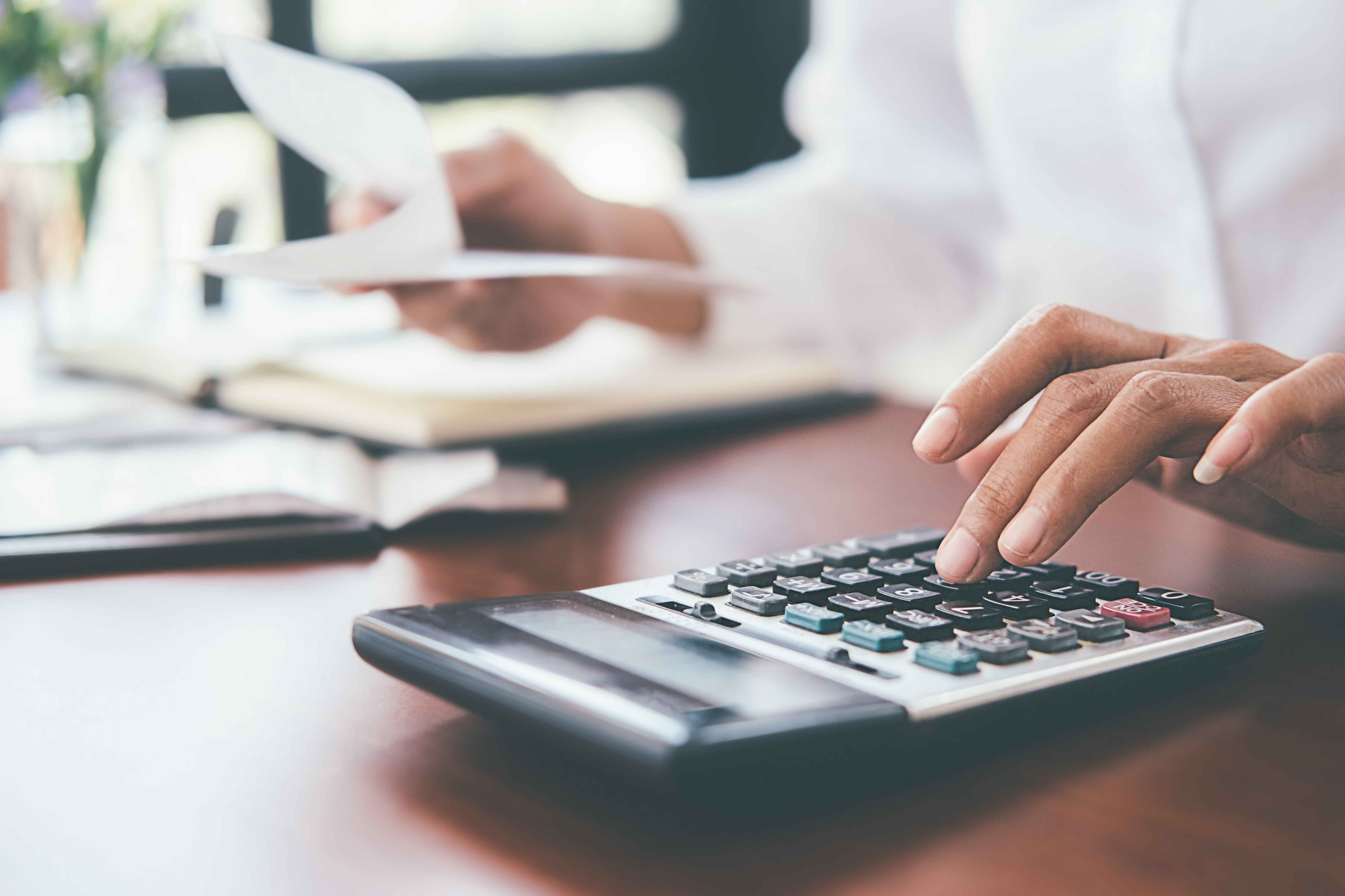 Gros plan d'une main utilisant une calculatrice