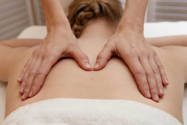 Gros plan de mains massant un dos