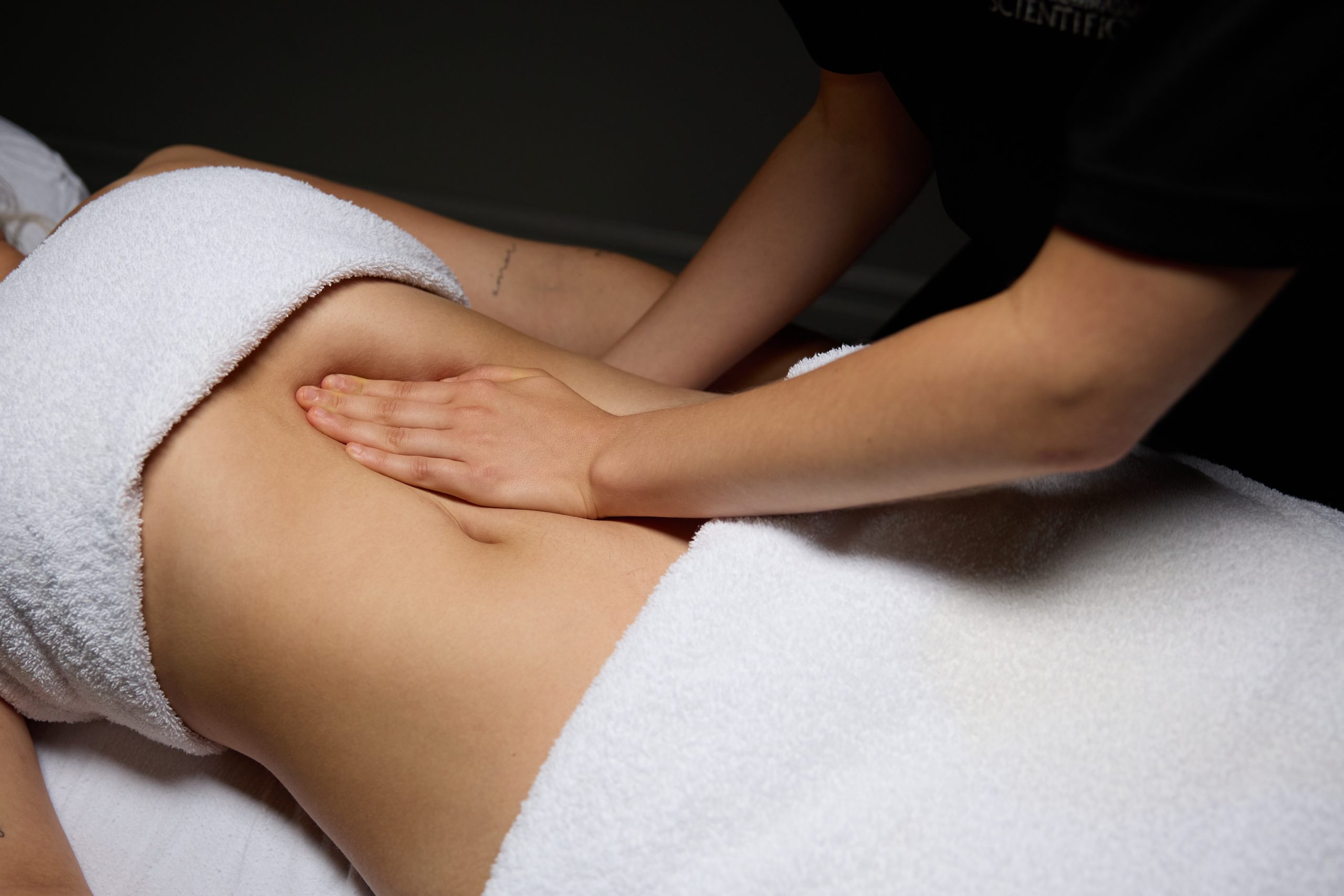 Main de thérapeute effectuant un massage ventral